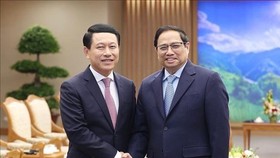 Prime Minister Pham Minh Chinh (R) receives Lao Deputy PM and Minister of Foreign Affairs Saleumxay Kommasith in Hanoi on December 7. (Photo: VNA)