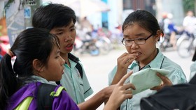 Thí sinh bàn luận sau khi kết thúc môn thi tiếng Anh tại hội đồng thi Nguyễn Thị Thập, quận 7. Ảnh: HOÀNG HÙNG