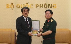 國防部長吳春歷大將(左)向日本駐越南特命全權大使梅田邦夫閣下贈送紀念品。（圖源：互聯網）