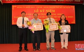 市內政處主任陳世琉(左)向各級黨委代表頒授黨齡紀念章。（圖源：VOH）