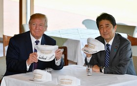 特朗普（左）與安倍晉三在一頂關於美日同盟的帽上簽名。（圖源：路透社）