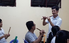 甘偉恒老師在教學生吹簫。