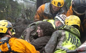 緊急救援人員從坍塌的家裡救出一名渾身裹滿泥土的女子。（圖源：路透社）
