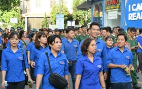 志願青年參加“接力上學徒步運動”。