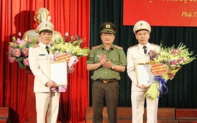 公安部副部長阮文成上將分別向范長江大校（左）和杜文宏大校（右）轉授公安部長簽發的調任《決定》。（圖源：寧家）