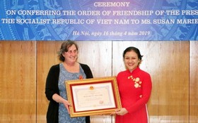 駐越南的戰爭遺產項目組織(WLP)創始人兼項目經理蘇珊‧瑪麗‧哈蒙德（左）從越南各友好組織聯合會(VUFO)主席阮芳娥手中接過獎狀。（圖源：越通社）