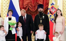 普京微笑著和受表彰的家庭合影。（圖源：Sputnik）