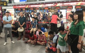 滯留峴港機場多個小時的乘客們聚集在機場內的 VietJet 客服櫃檯前等待著。（圖源：長中）