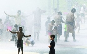 市民在噴水設施除去外衣消暑。（圖源：互聯網）