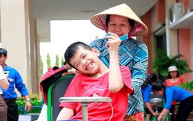 隆安省一名落葉劑受害少兒在獲贈手搖輪椅後的喜悅。