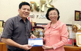 平仙公司副總經理陳芳珍(右)把贈報款項轉交給本報主編阮玉英(紅藍)。