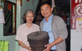 陳麗英老師（左）把放在家裡逾80年歷史的木製飯桶贈送給麒麟（右）。