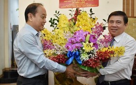 市人委會主席阮成鋒（右）向黎保霖老師贈送鮮花祝賀。（圖源：TL）