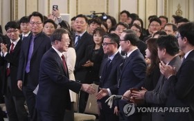 韓總統舉行新年記者會與在場人士握手致意。（圖源：韓聯社）
