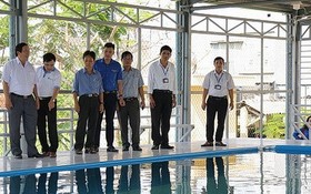 吉勝初中學校的老師們在觀察新建的游泳池。（圖源：VOV）