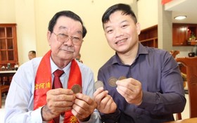 張興盛先生（左）向“西堤華人文化陳列室”成立計劃捐贈古銀元。