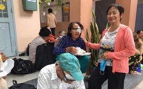 華人商販應氏蓮（右）向視障者派發營養餐。