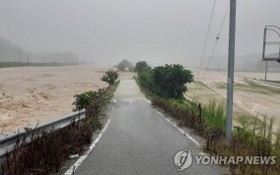 8月2日上午，位於忠清北道忠州市的永德川堤防遭暴雨襲擊垮塌，周圍的公路和農田被淹。（圖源：韓聯社）