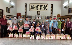 義安會館理事長陳裕(左一)向鄉親派發賑濟品。