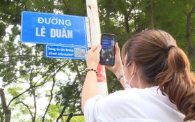 一名女遊客拍攝黎筍街名指示牌，以進一步了解該街名的歷史資訊。（圖源：明君）
