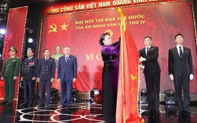 國會主席阮氏金銀為人民法院傳統旗幟上佩掛一等獨立勳章。（圖源：越通社）
