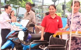 第五郡郡委書記阮文孝（左）向家境困難民戶轉交摩托車以作謀生工具。