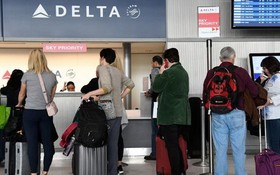 乘客在達美航空櫃檯辦理登機手續。（圖源：Getty Images）