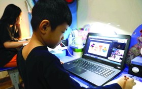 學生在家用電腦在線學習。