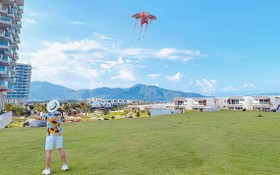 遊客在度假區海灘旁的草坪上放風箏。