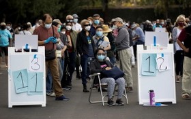 民眾在加州迪士尼樂園度假區接種疫苗的地點排長隊等候。（圖源：路透社）