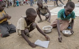 在烏干達的一個難民營帳區，南蘇丹孩子把派發糧食時掉在地上的榖物逐粒拾起來。（圖源：互聯網）