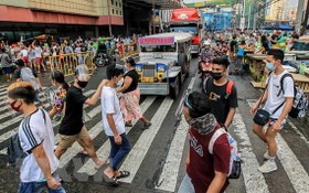菲律賓馬尼拉街頭的民眾佩戴防護用具出行。（圖源：新華社）