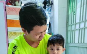 王鍾源抱著患癌症的幼兒家安。