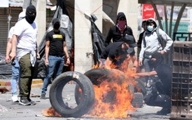 巴勒斯坦人在衝突中點燃了橡膠輪胎。（圖源：EPA）