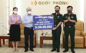 越南祖國陣線中央委員會主席杜文戰（左二）象徵性將各界同胞捐助抗疫的逾545億元款項轉交國防部。（圖源：潘草）