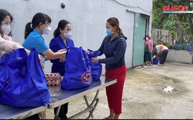 市人民議會主席阮氏麗（右二）向古芝縣受新冠肺炎疫情影響的工人與勞動者贈送禮物。（圖源：視頻截圖）