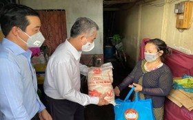 市人委會副主席吳明洲向第八郡遇困民戶贈送援助品。