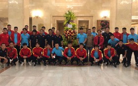 越南男子足球隊在國家主席贈送的花籃旁合影留念。（圖源：VFF）
