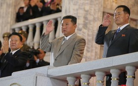 朝鮮最高領導人金正恩（中）罕見穿上一套灰色西裝出席閱兵式。（圖源：朝中社）