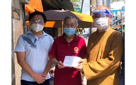 市華人佛教代表釋慧功（右一）與麒麟（左一）向啟秀華文中心校長王沛川贈送慰問金。