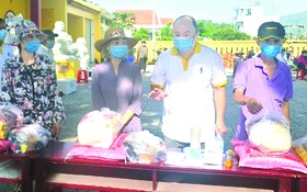 芽莊廣東會館理事長鄭成龍向貧民派發糧食。