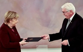 當地時間26日，德國總統施泰因邁爾在默克爾政府卸任儀式上，向默克爾遞交了任期結束通知，默克爾正式卸任總理。（圖源：路透社）