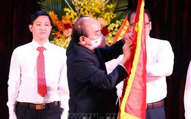 國家主席阮春福為河內師大傳統旗幟別上一等勞動勳章。