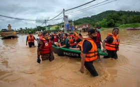 12月19日，在馬來西亞雪蘭莪州烏魯冷岳，救援人員轉移受洪水圍困的災民。連日降雨導致馬來西亞部分地區發生洪災。（圖：新華社）