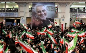 蘇萊曼尼遇襲兩週年，伊朗民眾手持他的肖像畫和伊朗國旗，聚集在首都德黑蘭參與紀念活動。（圖：AFP）