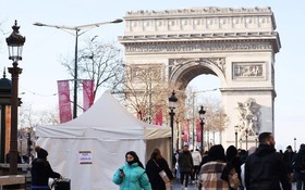 人們走過法國巴黎凱旋門附近的一處新冠病毒檢測點。（圖：新華社）