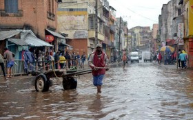 當地時間2月6日，在馬達加斯加首都塔那那利佛，一名男子蹚水走過淹沒的道路。馬達加斯加內政部7日說，強熱帶氣旋“巴齊雷”日前襲擊馬達加斯加，造成至少20人死亡，近7萬人被迫轉移。（圖：新華社）