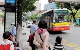 乘客在公交站台上等候巴士進站。（圖：新河內報）