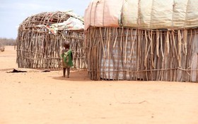 圖為 8月26日，一名兒童走在遭受旱災的肯尼亞馬薩比特郡萊薩米斯鎮一干旱的村莊內。（圖：新華社）