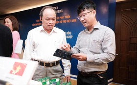 中南EMS股份公司經理阮英輝（右）在2022年峴港配套工業對接會議上介紹了該企業生產的電路板。（圖：晉力）